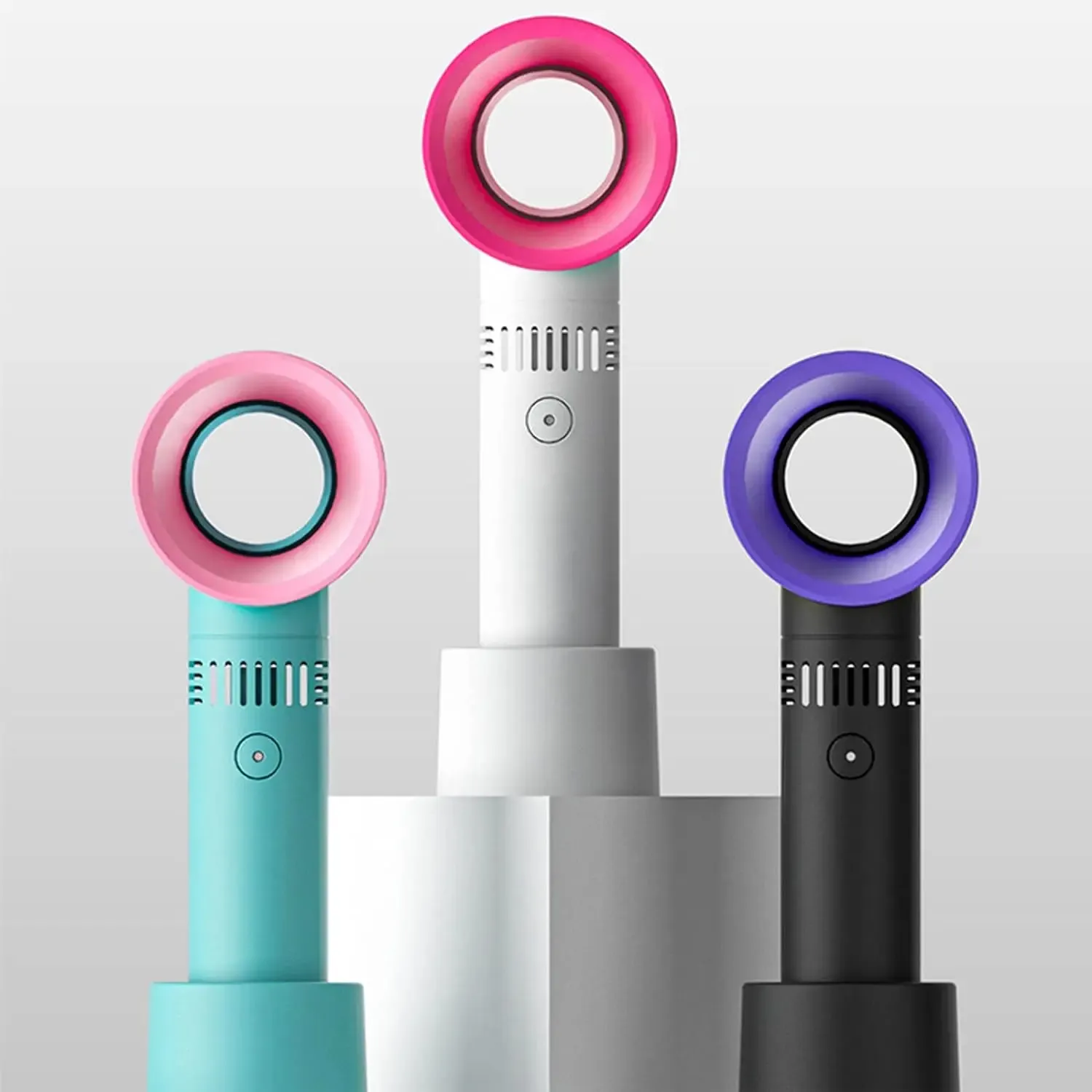 Three colorful handheld fans in pink, blue, and purple on a light gray background