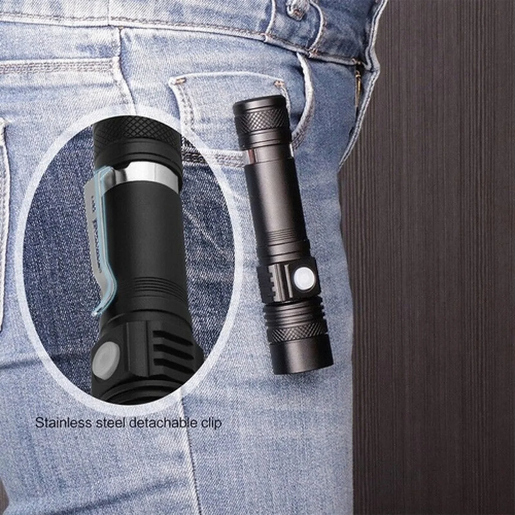Black flashlight with stainless steel detachable clip on blue denim background