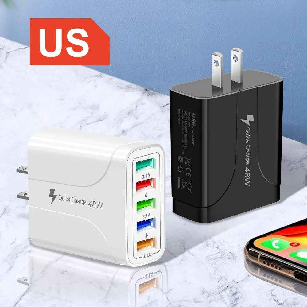 Two charging adapters, one white and one black, on a marble surface with a smartphone in the background.
