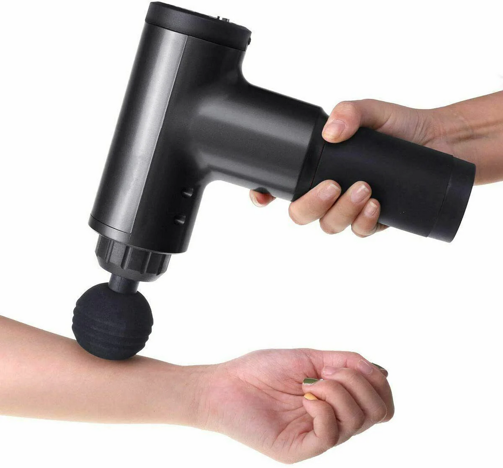 Person using a handheld massage gun on their arm against a white background