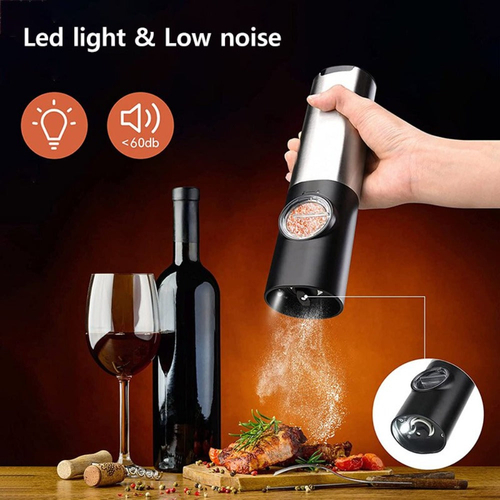 Electric pepper grinder being used with a glass of wine, bottle, and food on a wooden table.