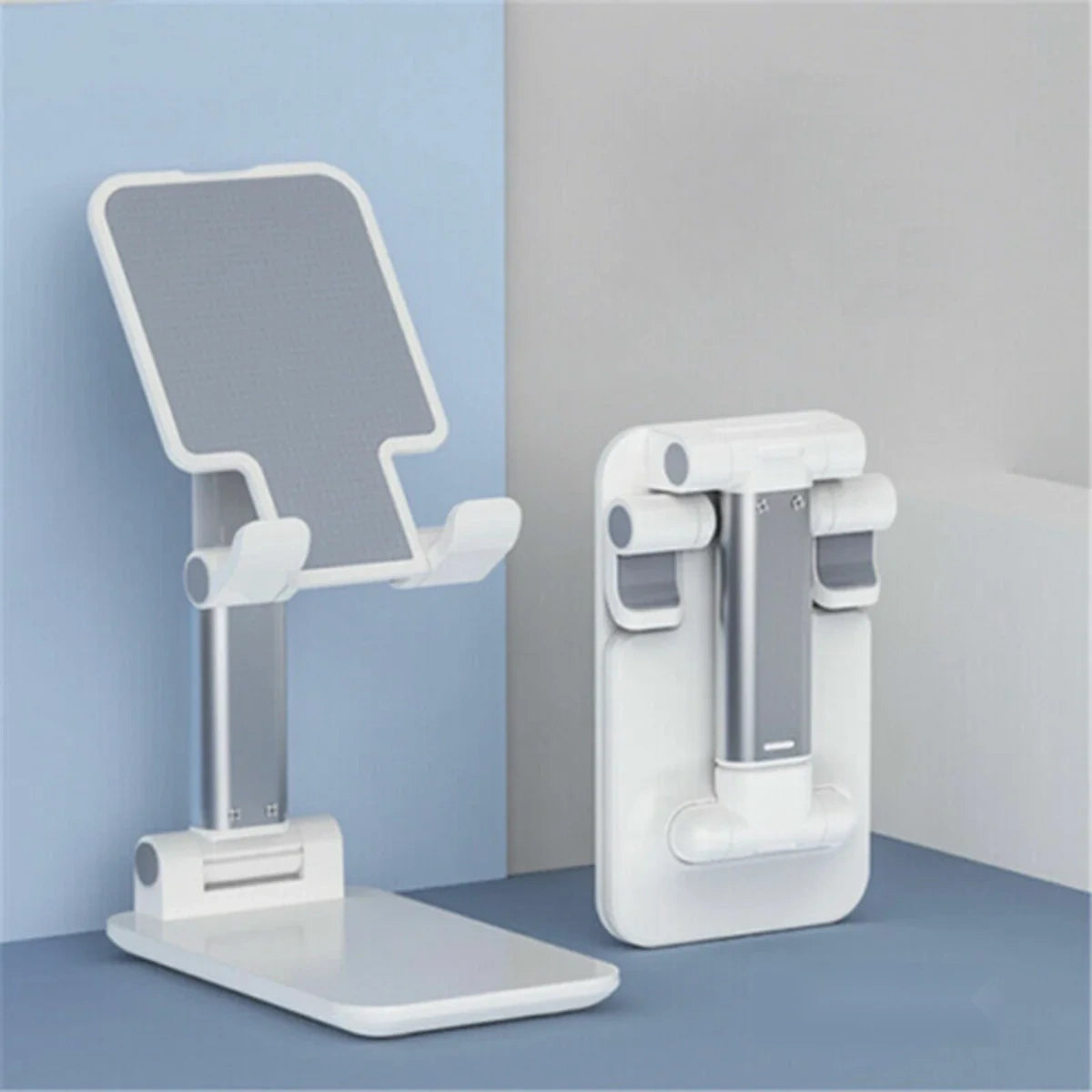 A white and silver adjustable desk stand shown in two positions: one unfolded with a tilted screen angle and one folded flat against a blue and gray background.