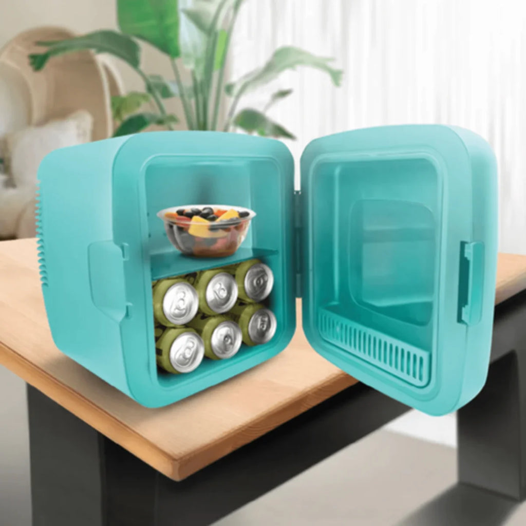 Turquoise mini refrigerator with open door showing drinks and snacks on a wooden surface.