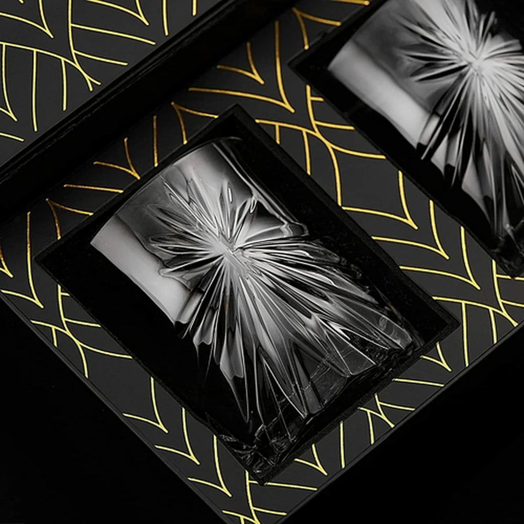 Decorative glass tumblers in a black box on a patterned surface