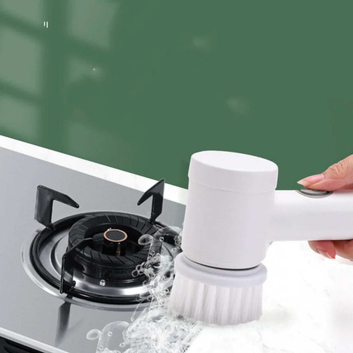 Person using a white scrubber to clean a gas stove with water splashes.